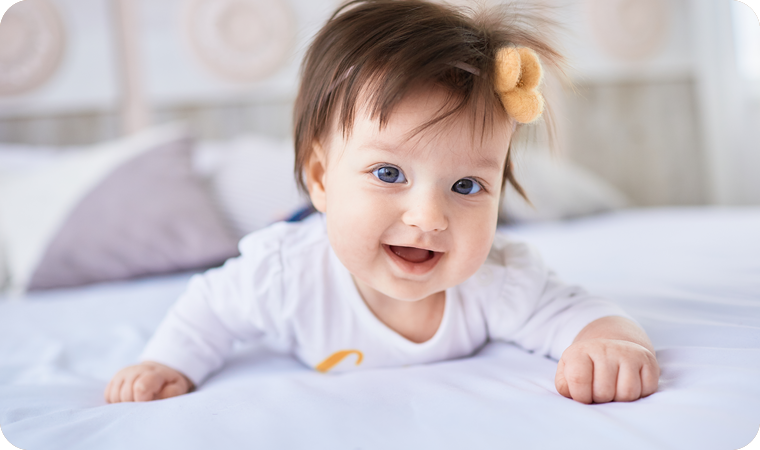 Smiling baby on a bed